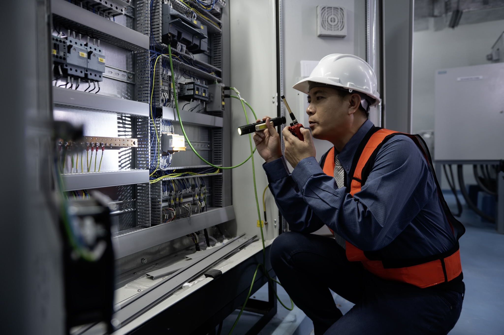 Worker examining electrical panel